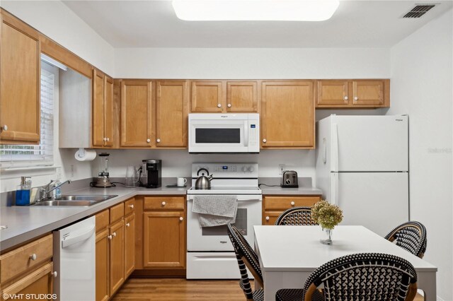 kitchen featuring light wood-type flooring, white appliances, and sink