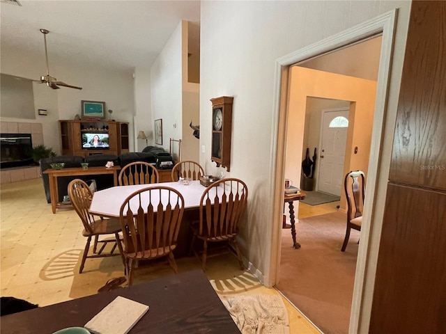 interior space featuring carpet flooring, ceiling fan, and a tile fireplace