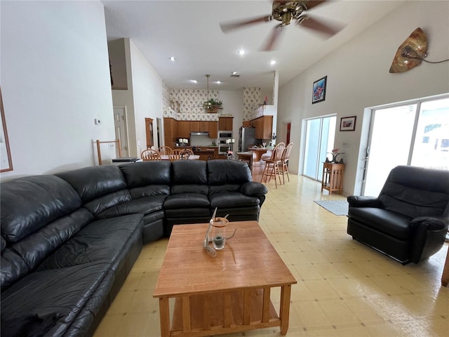 living room featuring a towering ceiling and ceiling fan