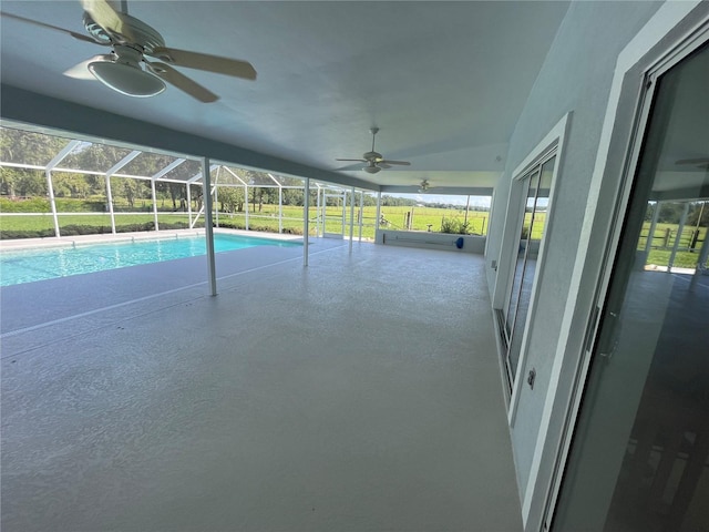 pool featuring ceiling fan, glass enclosure, and a patio area