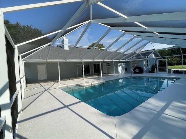 view of swimming pool featuring a lanai and a patio