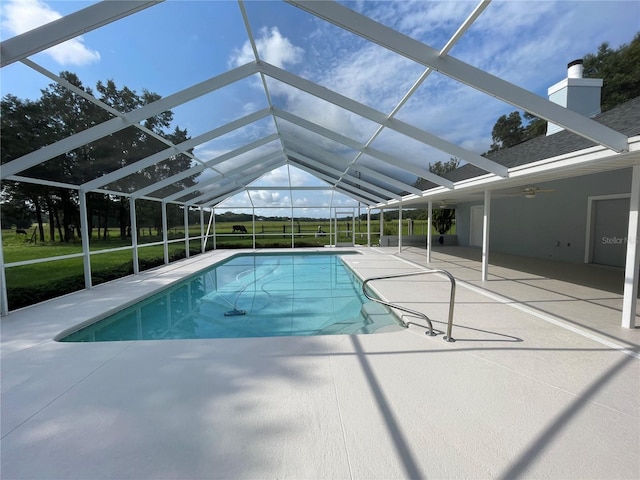 pool featuring a patio, glass enclosure, and a ceiling fan