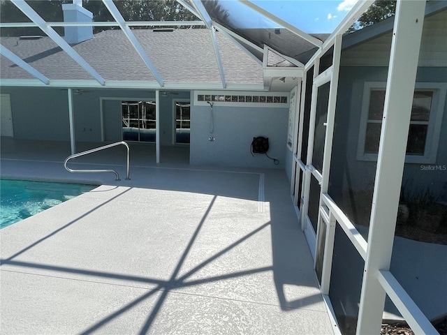 pool with glass enclosure and a patio area