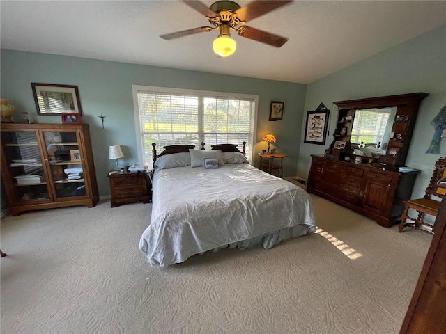 bedroom featuring a ceiling fan, lofted ceiling, light colored carpet, and multiple windows