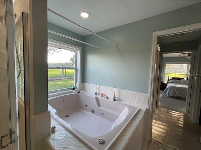 ensuite bathroom with ensuite bath, a tub with jets, and a wealth of natural light