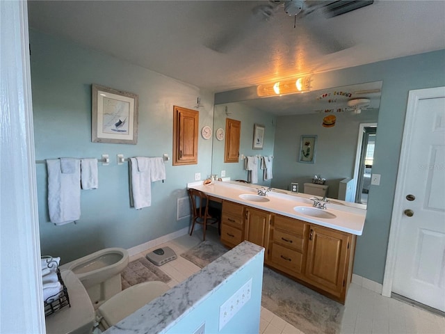 bathroom featuring a bidet, vanity, toilet, and tile patterned floors