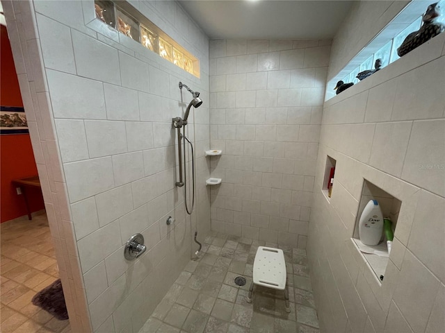 bathroom featuring tile walls, a tile shower, and a wealth of natural light