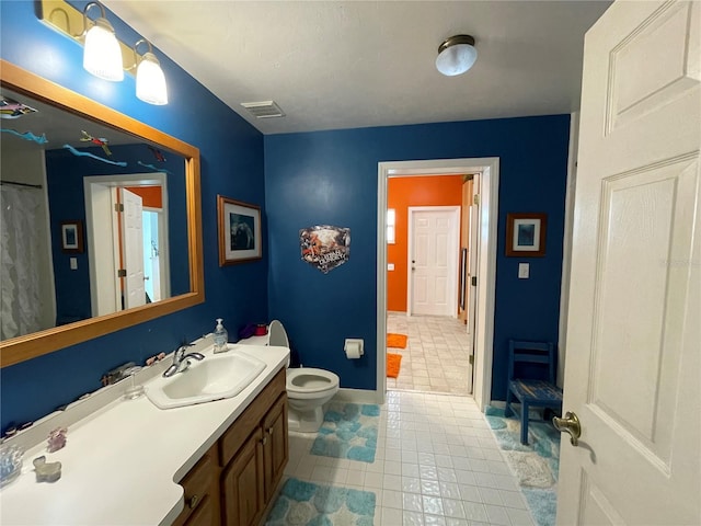 bathroom featuring tile patterned floors, toilet, and vanity