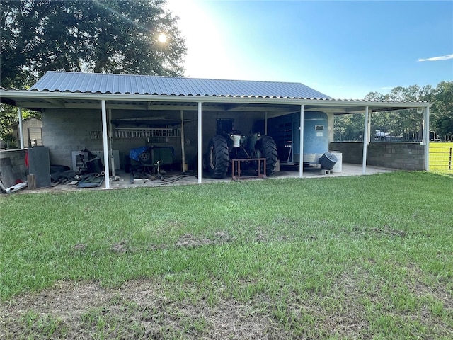 rear view of house with an outdoor structure and a lawn