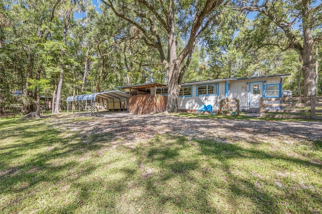 view of front of home with a front yard and a carport