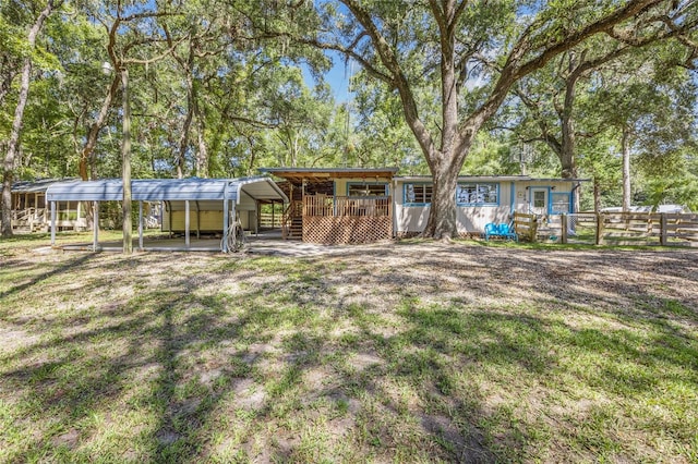 back of property with a lawn and a carport