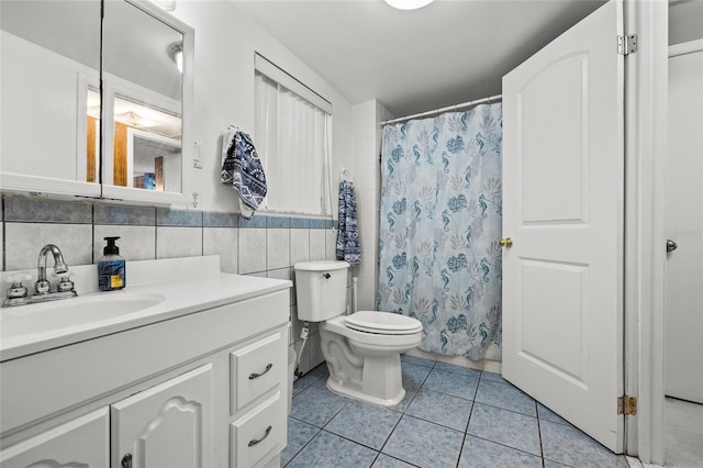 bathroom with tile patterned floors, toilet, a shower with shower curtain, tile walls, and vanity