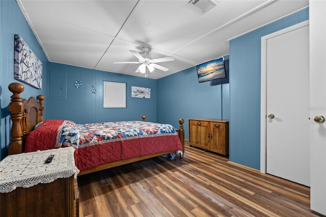 bedroom with wood finished floors, visible vents, and ceiling fan