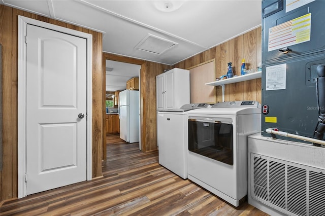laundry room with attic access, wooden walls, cabinet space, and separate washer and dryer