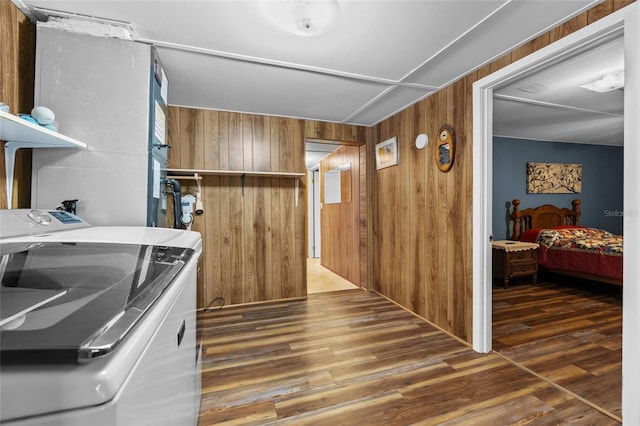interior space with washing machine and clothes dryer, laundry area, wood walls, and wood finished floors