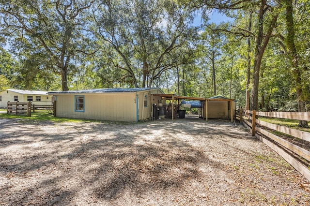 exterior space with an attached carport, driveway, and fence