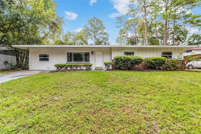 single story home featuring board and batten siding and a front yard