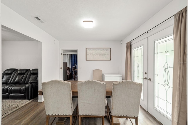 dining space featuring french doors, visible vents, and wood finished floors