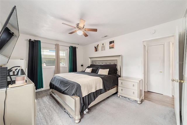 bedroom featuring visible vents, ceiling fan, and light carpet