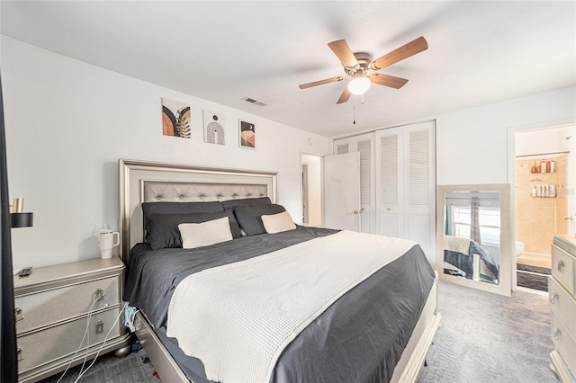 bedroom with a closet, visible vents, ensuite bathroom, a ceiling fan, and light carpet