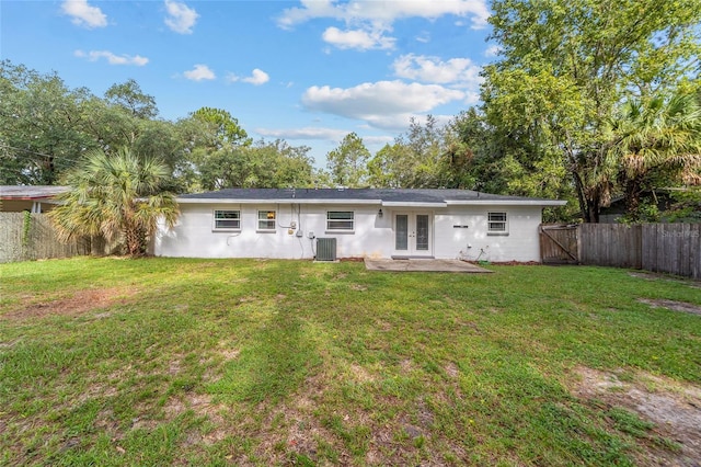 rear view of house featuring french doors, a fenced backyard, a lawn, and central AC unit