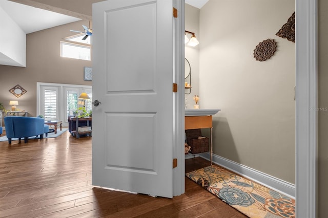 bathroom featuring ceiling fan, hardwood / wood-style flooring, and a towering ceiling