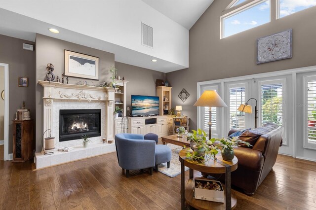 living room with hardwood / wood-style flooring, a fireplace, and high vaulted ceiling