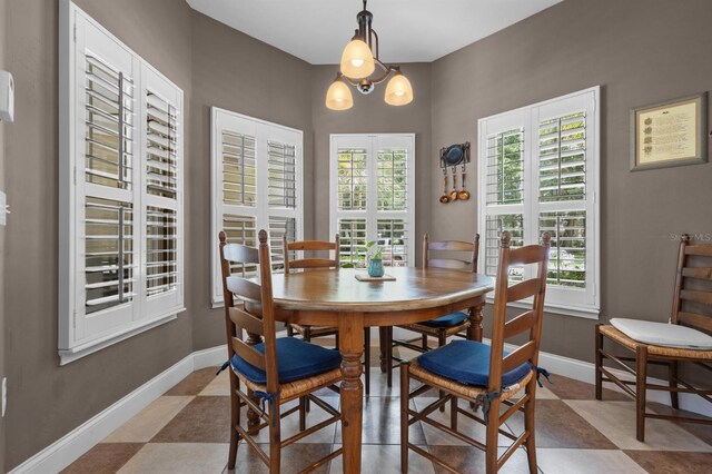 tiled dining space featuring a chandelier