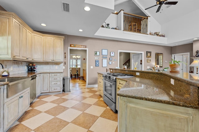 kitchen with ceiling fan, tasteful backsplash, a high ceiling, light tile patterned flooring, and stainless steel appliances