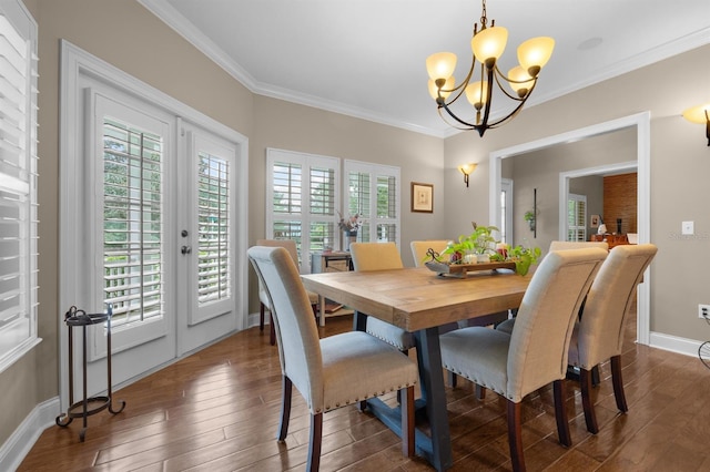 dining area with crown molding, dark hardwood / wood-style flooring, an inviting chandelier, and french doors