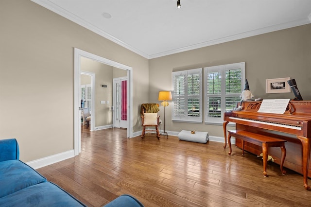 sitting room with wood-type flooring and ornamental molding