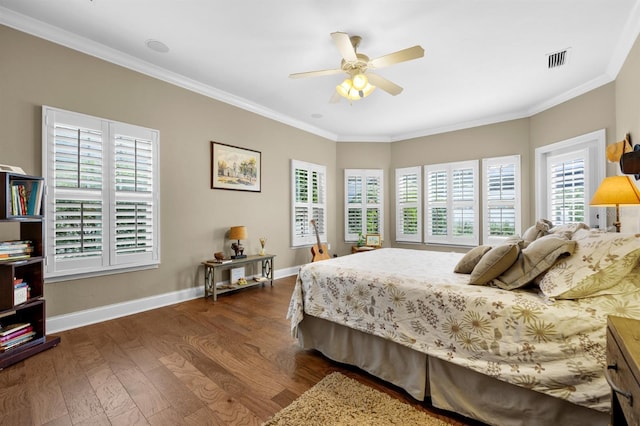 bedroom with dark hardwood / wood-style flooring, ornamental molding, and ceiling fan