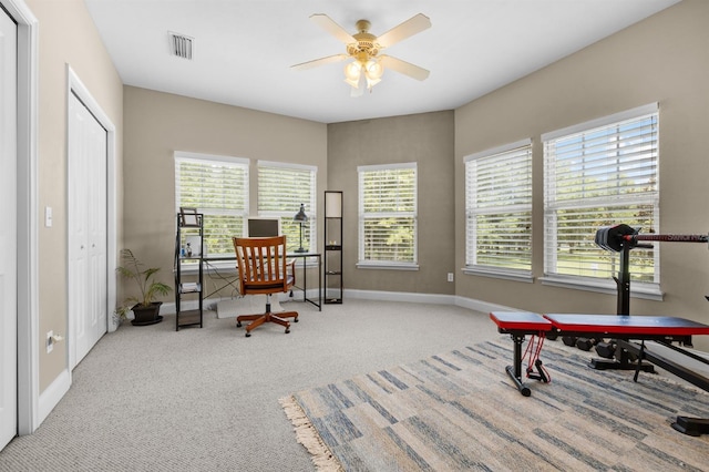 carpeted home office featuring ceiling fan