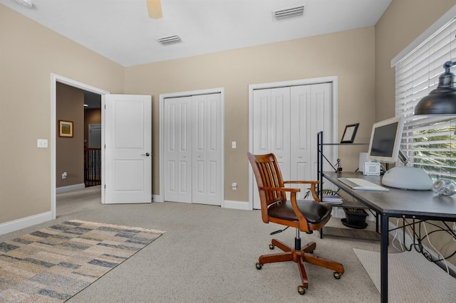 carpeted office space featuring ceiling fan