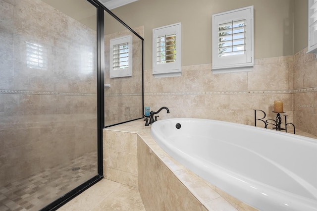 bathroom featuring tile patterned floors, shower with separate bathtub, and tile walls