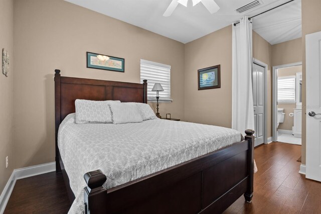 bedroom featuring ceiling fan, ensuite bathroom, and dark hardwood / wood-style flooring