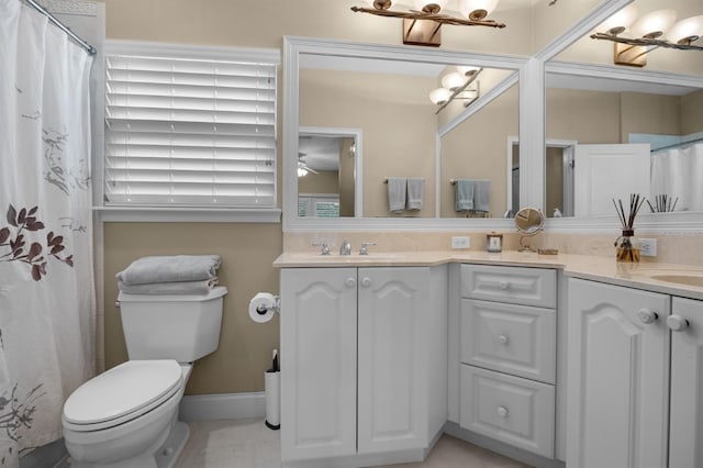 bathroom with tile patterned floors, double sink vanity, and toilet