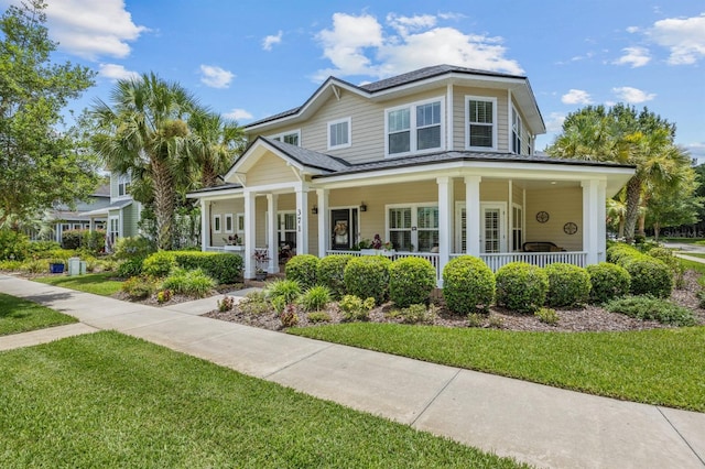 view of front of house with covered porch and a front lawn