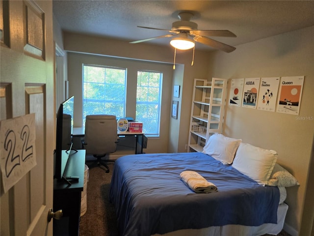 bedroom with ceiling fan, a textured ceiling, and carpet flooring