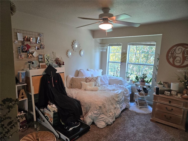 bedroom featuring a textured ceiling, carpet, and ceiling fan