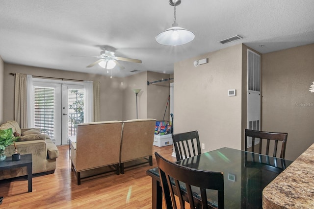 dining space with ceiling fan and light wood-style floors