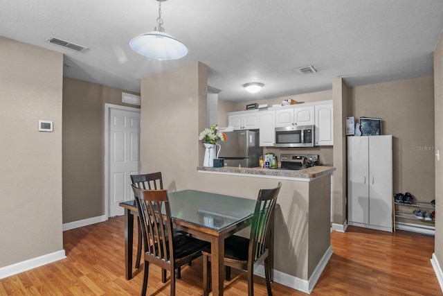 dining space featuring light wood-type flooring and baseboards