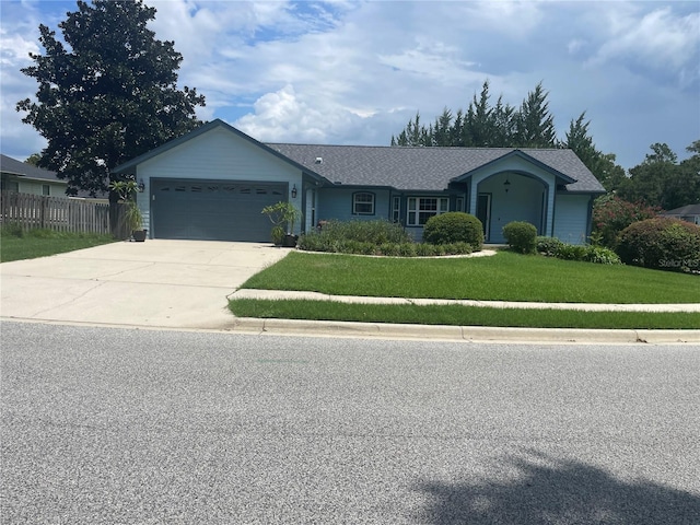 ranch-style house featuring a garage and a front lawn