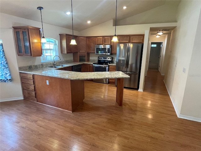 kitchen with stainless steel appliances, hardwood / wood-style floors, sink, and pendant lighting