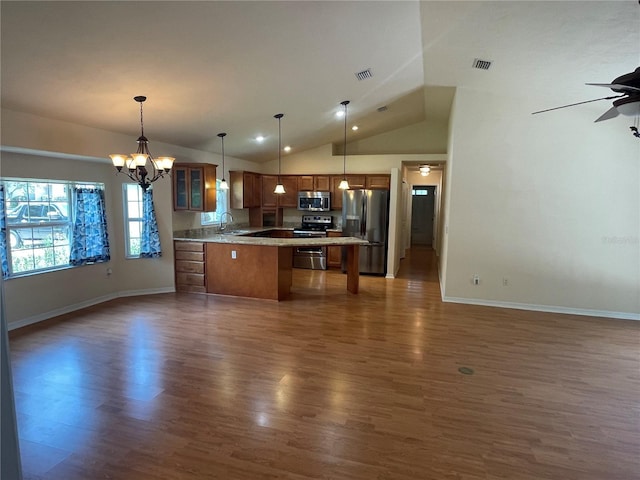 kitchen featuring sink, appliances with stainless steel finishes, dark hardwood / wood-style flooring, pendant lighting, and ceiling fan with notable chandelier