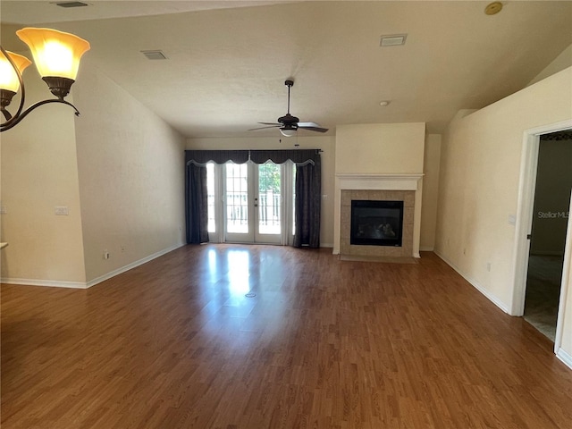 unfurnished living room featuring a fireplace, dark wood-type flooring, french doors, and ceiling fan