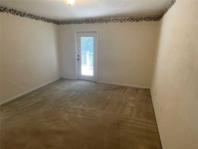 spare room with dark carpet