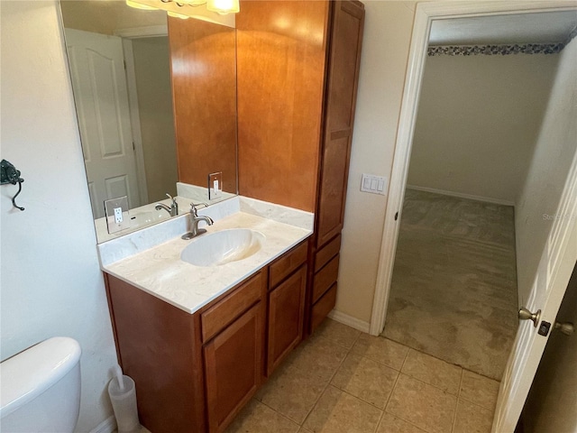 bathroom with tile patterned flooring, vanity, and toilet