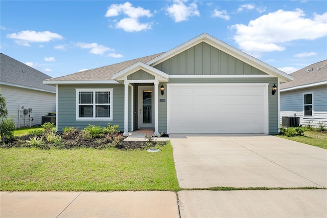 view of front facade with a garage, central AC unit, and a front yard