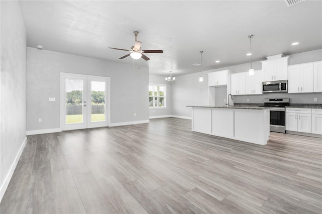 kitchen with white cabinetry, appliances with stainless steel finishes, decorative light fixtures, and an island with sink